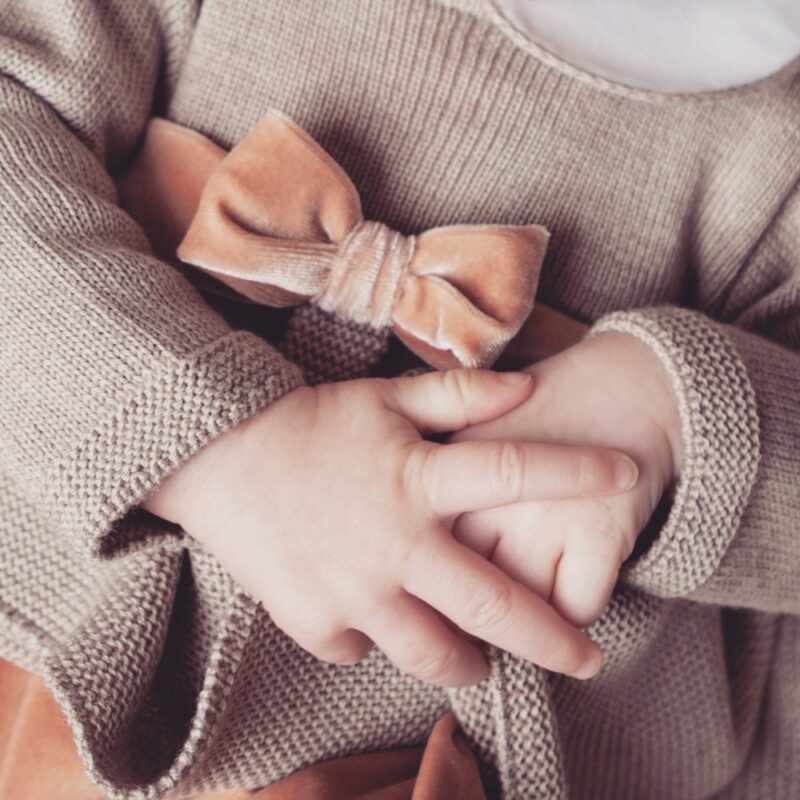 Tutina intera per neonato in lana merino color corda con cinta e fiocco in velluto cipria